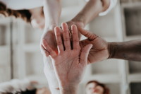 Ansicht von unten auf mehrere aufeinander liegende Hände