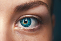Blaues Auge einer Frau, die gerade in die Kamera schaut