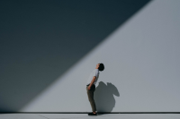 Mann schaut nach oben auf den Schatten an der Wand neben ihm