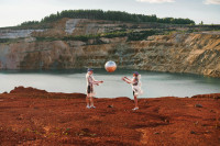 Futuristisches Bild, zwei Personen mit einem silbernen Ball in Marslandschaft