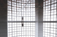 Mann steht vor sich spiegelndem Wasserbecken in einem Gebäude