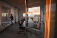 Das Abendlicht und die Spree spiegeln sich in den großen Fenstern eines Konferenzraumes.